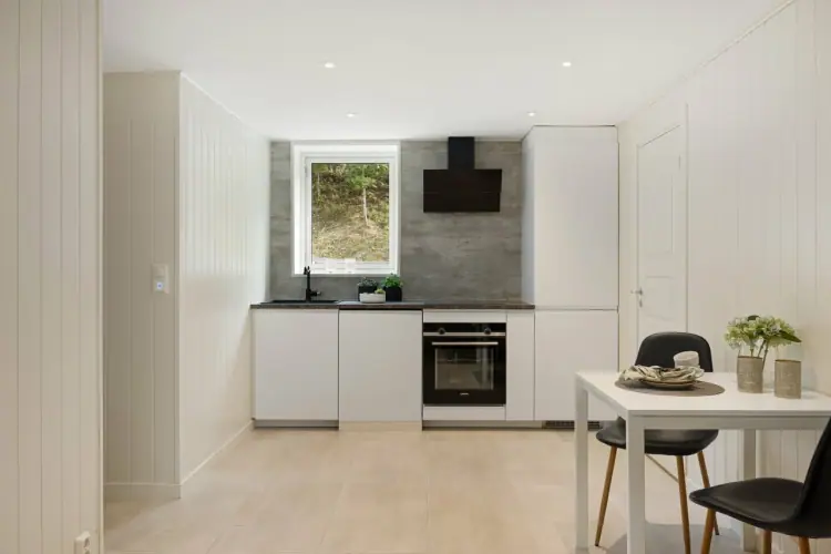 Kjøkken sett fra spisebordet, i åpen løsning med resten av rommet.