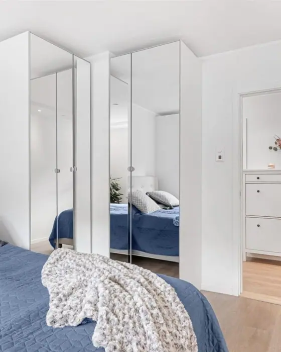Soverom med speilgarderobe langs veggen og dør ut til gangen.